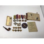 A WWII medal group including the Africa and Italy Stars with cap badges, shoulder titles, etc.