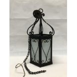A hexagonal metal work and glass hanging porch lantern with chain.