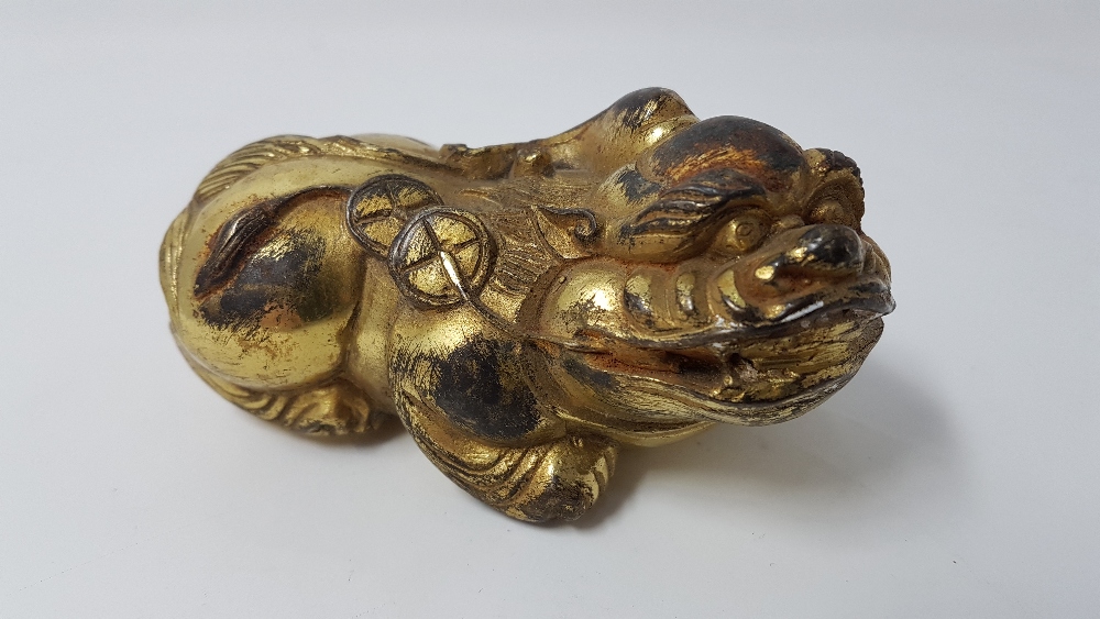 A squat gilded metal figure of a dog of foe.