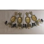 A set of four early 20th Century brass electric double wall sconces.