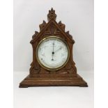 A Joseph Seymour Tanner circular oak cased barometer with curved thermometer.