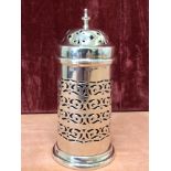 A cylindrical silver sugar sifter with pierced decoration and blue glass liner.