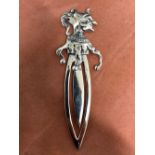 A silver bookmark in the form of a court jester.