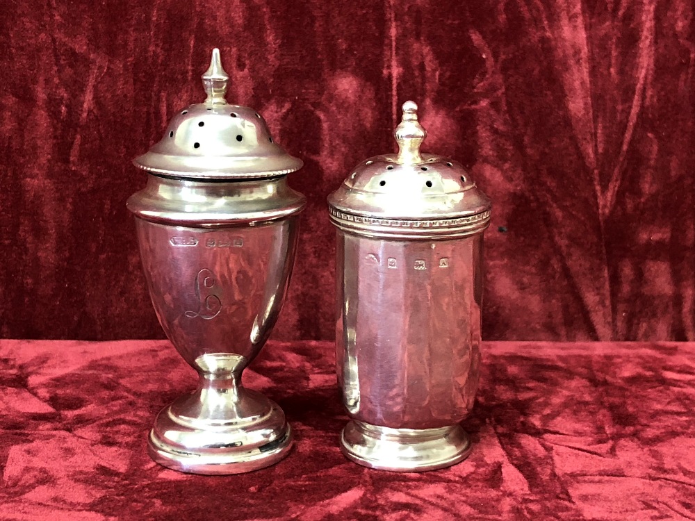 Two silver pepper shakers.