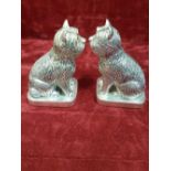A pair of silver cruets in the form of terrier dogs with ruby eyes.