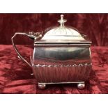 A silver rectangular lidded mustard pot with blue glass liner.