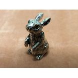 A cast silver figure of a seated rabbit.