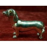 A silver figure of a dachshund dog.