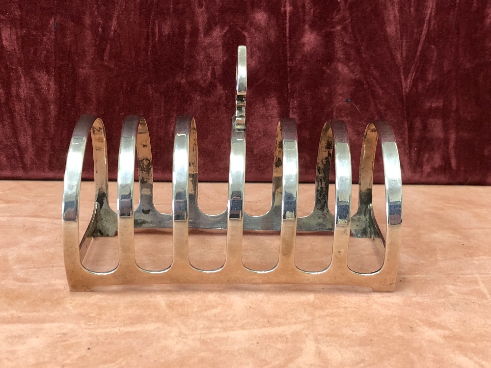 A silver six slice toast rack with Liberty style carrying handle.