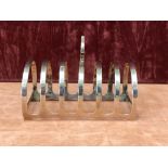 A silver six slice toast rack with Liberty style carrying handle.