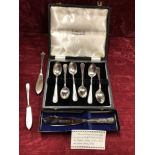 A cased set of six silver tea spoons plus knives.