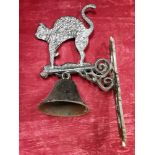 A wall mounted cast metal bell with black cat.