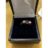 A 10ct white gold ruby and diamond three stone ring.