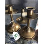 A pair of iron and brass candlesticks and a brass chamber stick with ejectors.