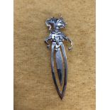 A silver bookmark in the form of a jester.