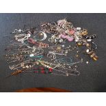A box of assorted costume jewellery, mostly necklaces.