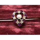 A 9ct gold, ruby and diamond sweetheart brooch.
