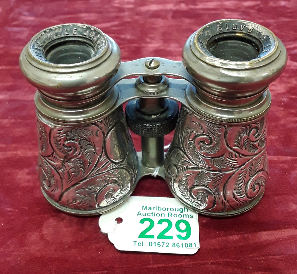 A pair of silver binoculars with floral scroll work decoration.