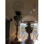 Two table oil lamps with shades.
