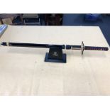 A Franklin Mint replica Samurai Ninja Sword on display stand.