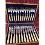 A wooden cased 24 piece silver collared fish cutlery set.