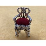 A silver pin cushion in the form of a Chippendale style chair.