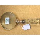 A large brass hand held magnifying glass.