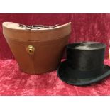 A silk top hat with leather carry case.