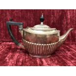 A silver teapot with ribbed decoration.