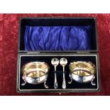 A boxed pair of silver salts together with two silver spoons.