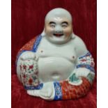 A large ceramic Buddha with seal to the base.