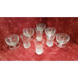 Five early 20th Century sundae dishes with integral saucers and four Edwardian glass beakers.