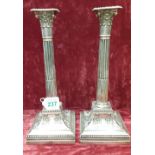 A pair of silver corinthian column candlesticks.