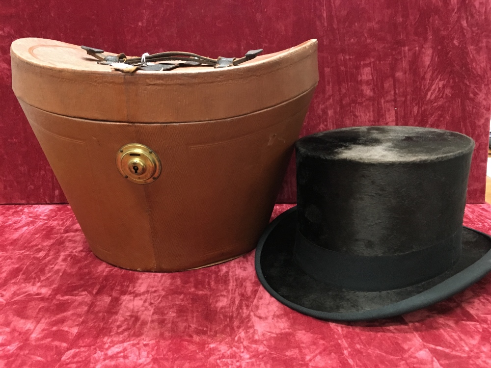 A silk top hat with leather carry case.