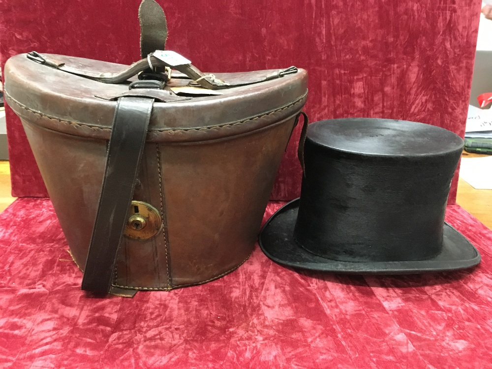 A vintage Christie's silk top hat with leather case.