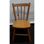 A small American oak child's wooden chair with plain spindle back. From Amish makers in Ohio.