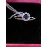 A 18ct white gold sapphire and diamond cluster ring. Approximately 1/2 carat. Size L.