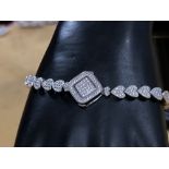 A silver heart shaped CZ bracelet with interlocking clasp.