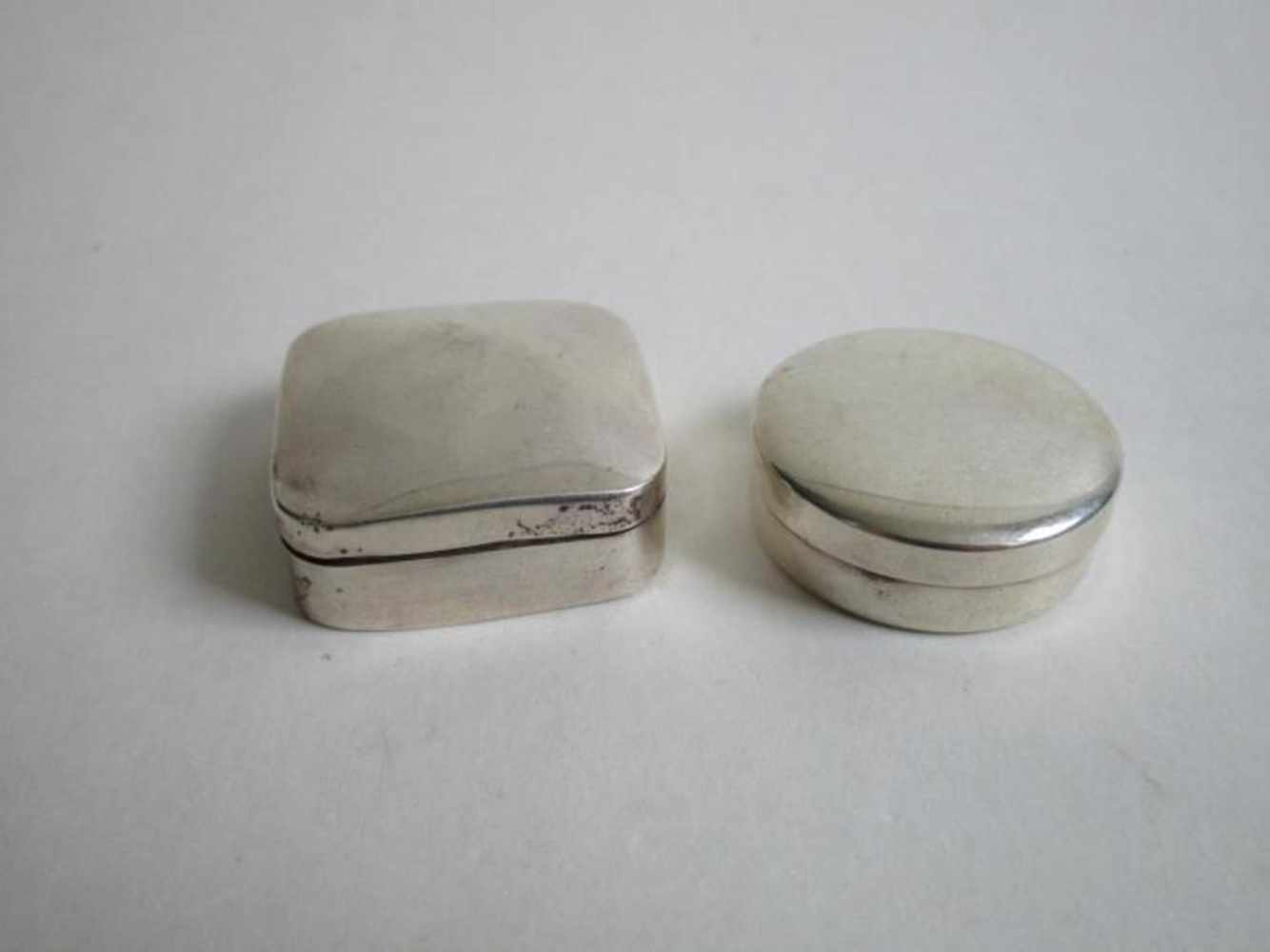 Twee zilveren miniatuur koektrommels, een vierkant en een rond, beide geheel glad.ca.18gr