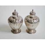 Twee balustervormige zilveren theebussen met drijfwerk van schelpen en acanthus bladmotieven.