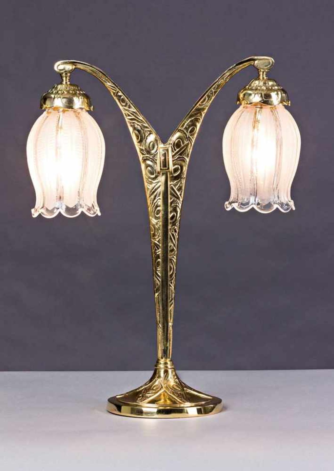 Jugendstil-Tischlampe. V-förmige Messinghalterung mit zwei Lichtstellen. Glasschirme. Um 1900. H