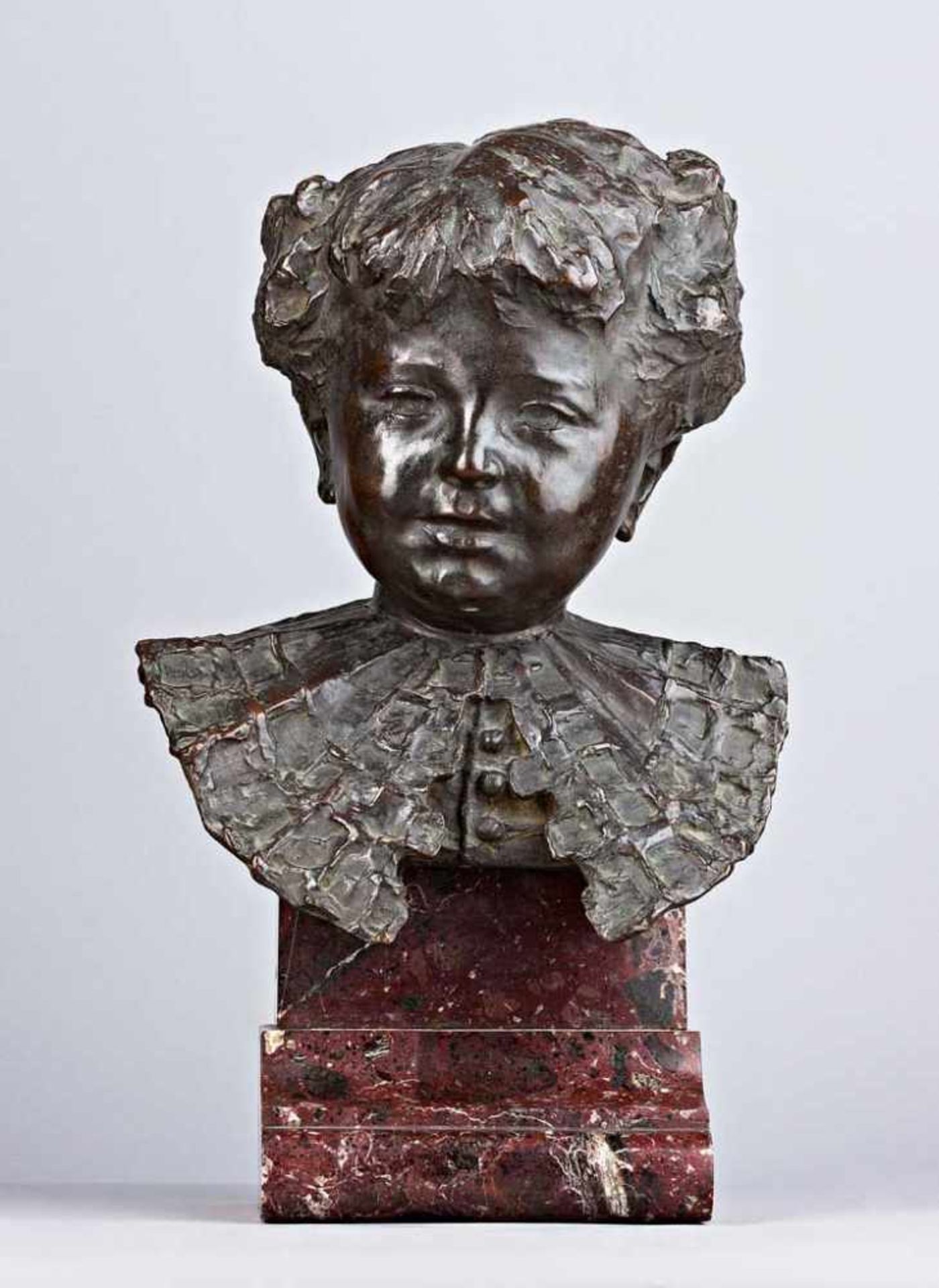 Kinderbüste mit Fächerkragen. Bronze. Auf Steinsockel, Gesamthöhe 47 cm