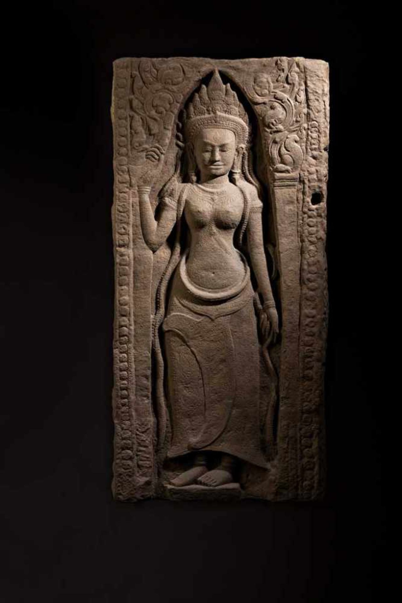 Devata als Bas-Relief. In Wandnische mit Spitzbogenabschluss stehende göttliche Tänzerin. Kunstvolle