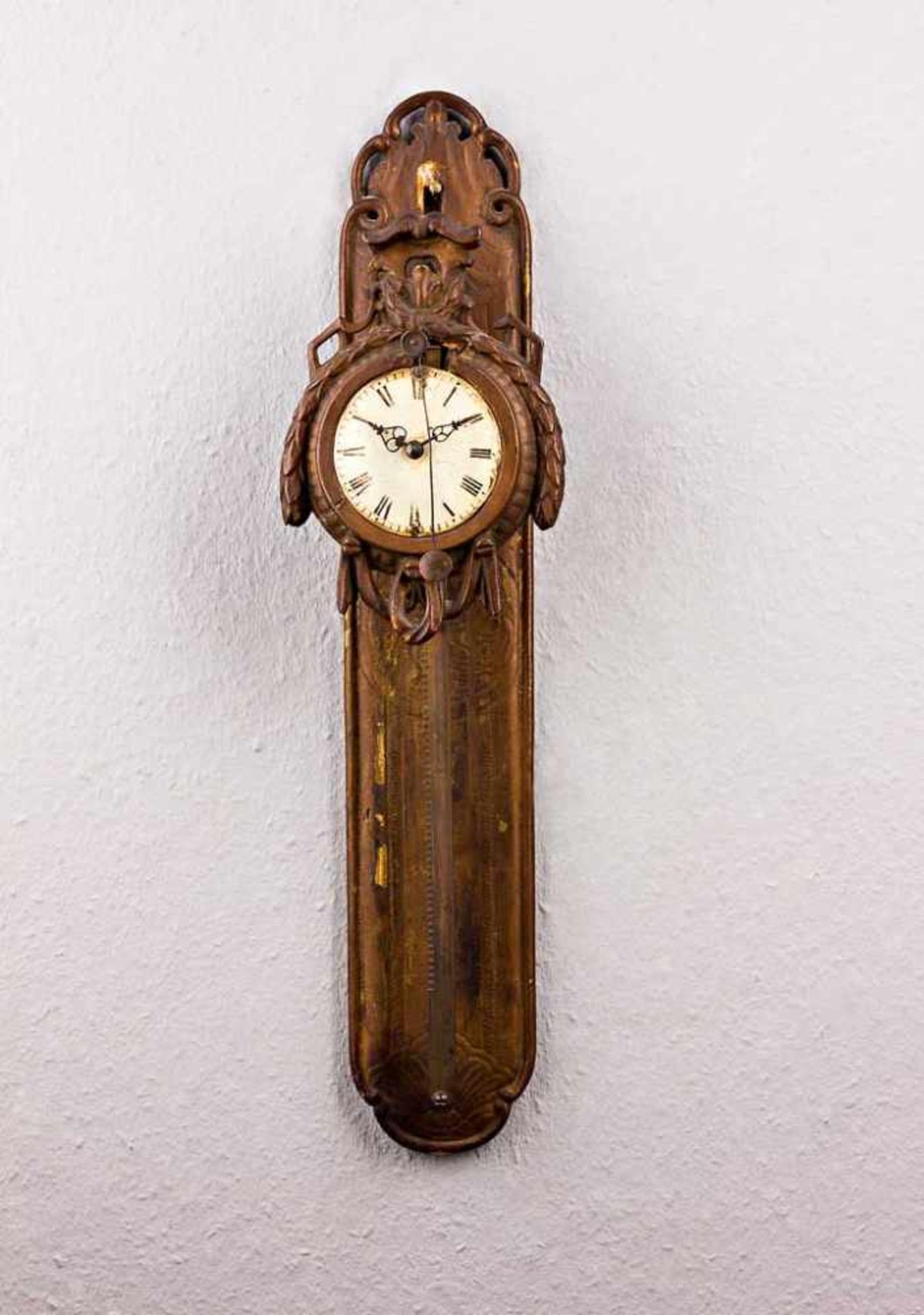 Wanduhr, sog. Sägeuhr. Geschnitzter bronzierter Zifferblattfronton (l. besch.). Rundes