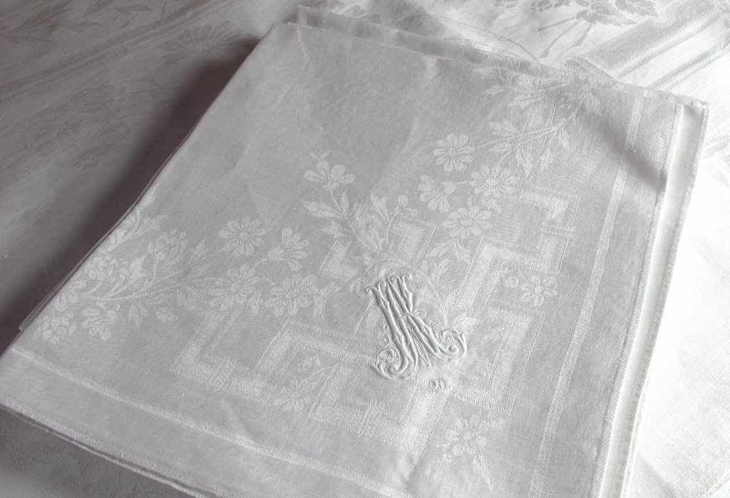 Tafelgarnitur mit Monogramm "AK": Tafeltuch und sechs Mundtücher. Damast mit Blumen- und graphischem