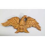 Adler als Emblem mit ausgebreiteten Schwingen. Vergoldetes Holzrelief. 1. H. 19. Jh. 32 x 72 cm