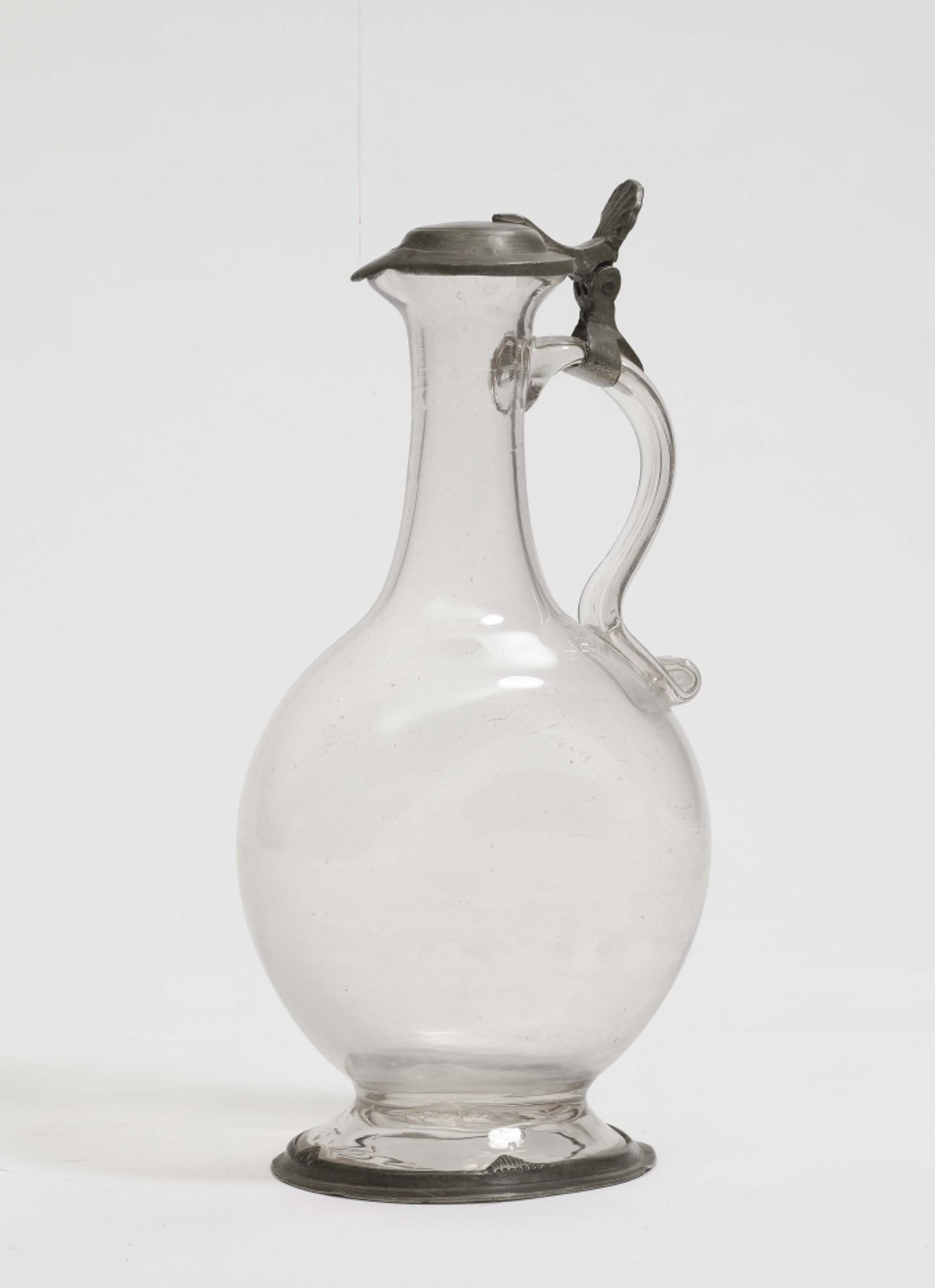 Kanne, 19. Jh. Glas. Gedrückter Korpus, eingerollter Glashenkel. Zinnmontierung. H. 25 cm. Spende