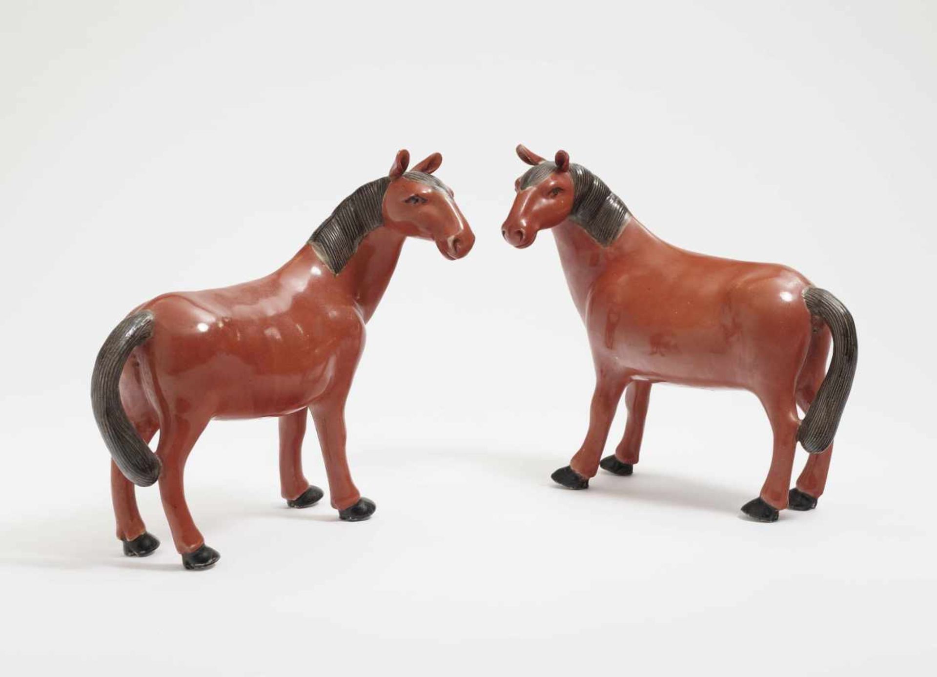 Ein Paar Pferde China Porzellan. Korallenrote Glasur. Min. rest. H. 19 cm. A Pair of Horses China