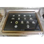 MILITARIA - A framed cap badge display produced by