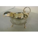 SILVER - A sterling silver sauce boat on 3 decora